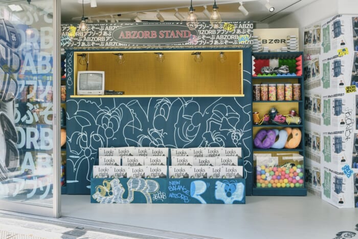 目印は「ABZORB アブゾーブ あぶぞーぶ」。渋谷駅前のスクランブル交差点に突如現れた、ニューバランスのマガジンスタンドにご注目を。